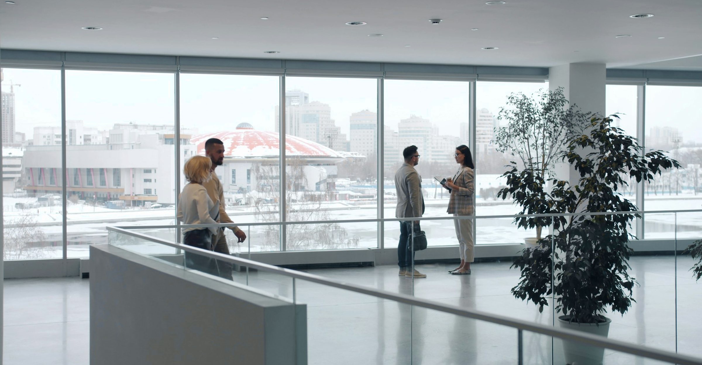 People talking in a bright office overlooking the city