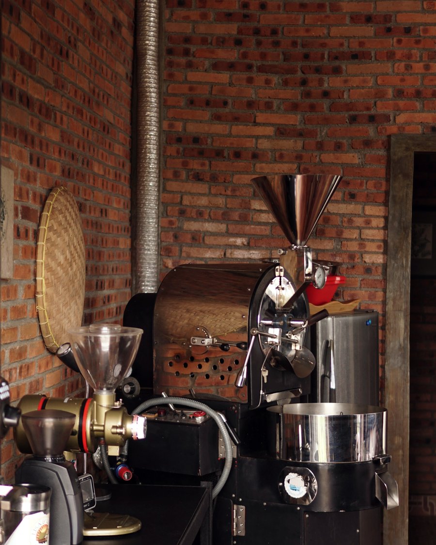 A coffee roaster in a brick-walled roastery